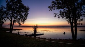 Una vista tranquila de un lago con árboles y un muelle.