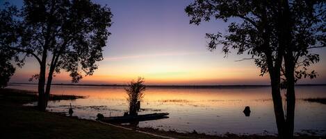 A serene lakeside view with trees and a dock.
