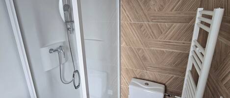 A modern bathroom with a glass-enclosed shower, a toilet, and a radiator.