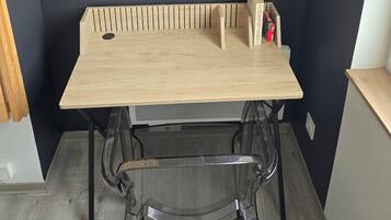 Un comedor con una mesa y sillas de madera, fotografías enmarcadas en la pared y una pequeña caja de madera sobre la mesa.
