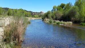 A river flowing through a natural landscape with trees and a distant village. - Apartment in Gréoux-Les-Bains near Lakes (Gréoux-les-Bains)