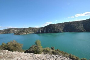 A lake surrounded by rocky terrain and sparse vegetation.