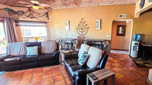 Una sala de estar acogedora con chimenea, comedor y un amplio ventanal.