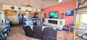 A living room with a TV, a fireplace, and a dining area with a table and chairs.