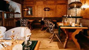 Un intérieur chaleureux en bois, avec un coin repas, des bancs et une cheminée.