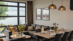 Ein moderner Essbereich mit großem Fenster, einer Couch und einem gedecktem Tisch.
