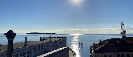 A waterfront view with buildings, a clear sky, and a calm sea.