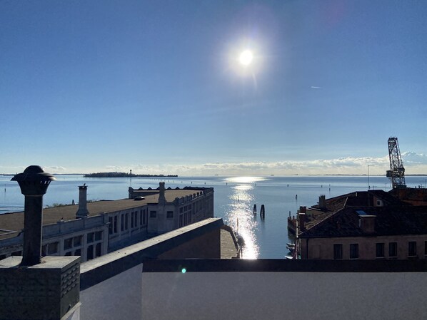 A waterfront view with buildings, a clear sky, and a calm sea.