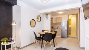 Une cuisine moderne avec un coin repas, comprenant une table ronde avec des chaises, un réfrigérateur et un évier.