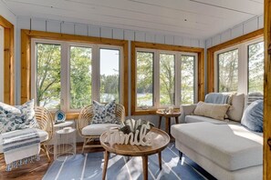 A cozy room with a large window, a sofa, a chair, and a small table. - La Belle Vue - Beautiful Sunsets on Long Lake (Torrance)
