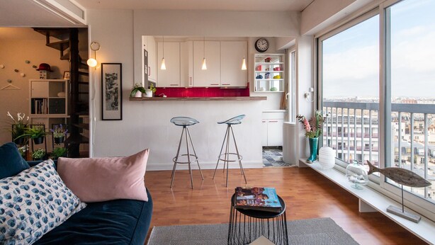 A modern apartment with a kitchen, two bar stools, a sofa, a coffee table, and a large window with a city view. - MONTMARTRE, PARIS VIEW, ATTRACTIONS, 30–60 days ahead? Ask Private offer VIE-VAp (Paris)