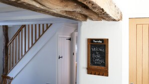 A staircase with wooden railings leading to a door. A chalkboard sign on the wall reads "Thursday Welcome to Belgrade Cottage." - This charming 18th Century cottage is centrally located in the heart of St Teath (St Teath)