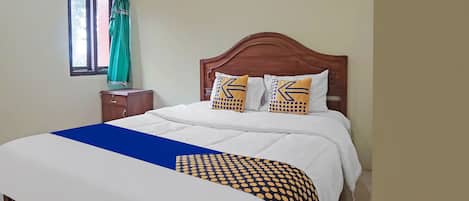 Relax in a cozy space with a neatly made bed and a geometric-patterned nightstand.