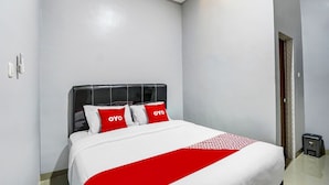 A hotel room with a bed, white walls, and a red and white bedspread. - Hotel O Beda Arga Near Rs Royal Prima Ayahanda (Medan)