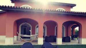 Un edificio con archi, un'amaca e poltrone reclinabili.