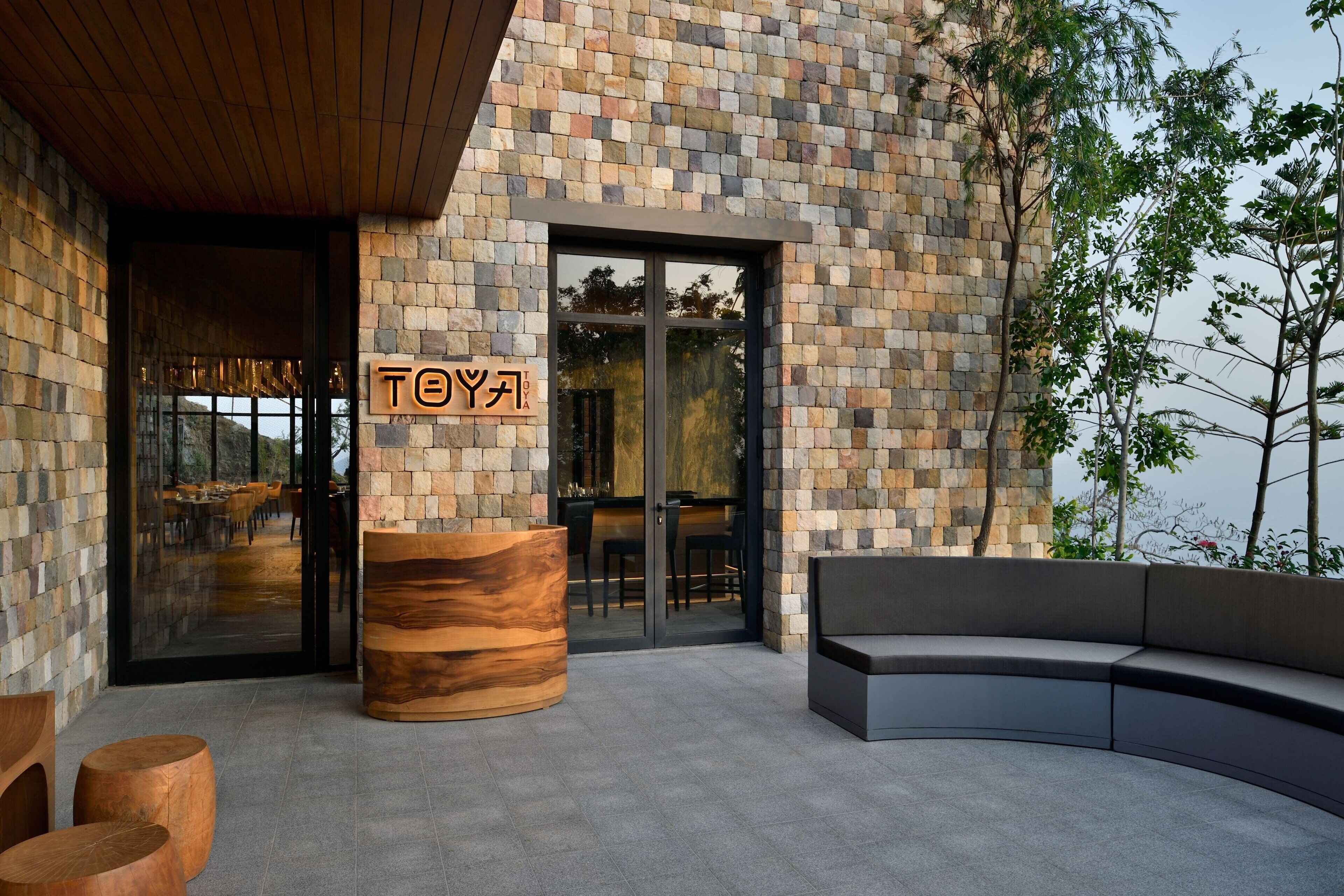 A modern building with a stone facade and a wooden reception desk.