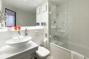 A modern bathroom with a large sink, toilet, and glass-enclosed shower. - Dormero Hotel Hannover-langenhagen Airport (Langenhagen)