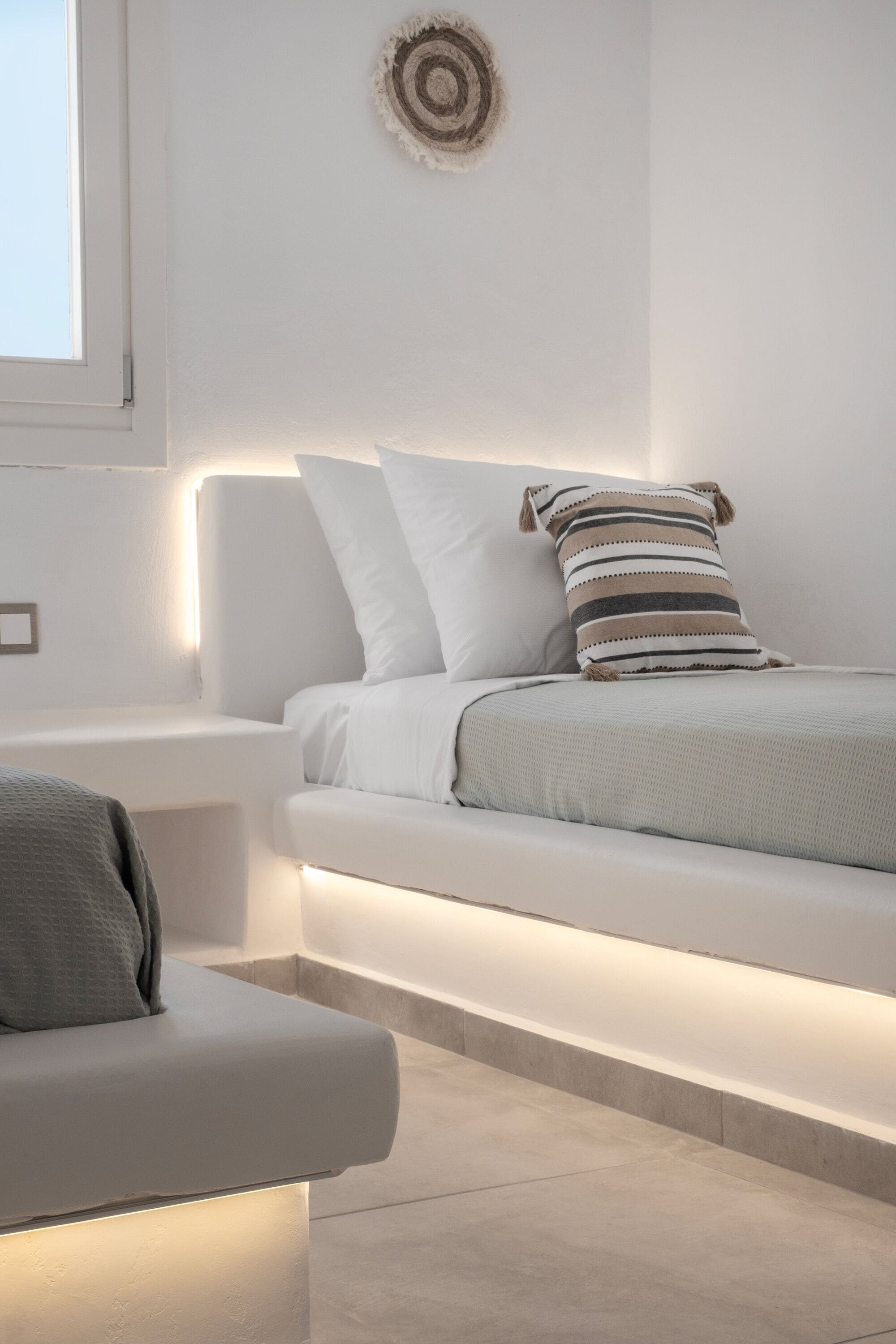 A modern bedroom with a built-in bed, bedside tables, and a window.
