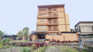 Een meerlaags gebouw met een modern ontwerp, voorzien van balkons en een hekpoort.
