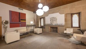 A spacious room with a fireplace, modern furniture, and a unique wall art piece. - Mendez Nunez (Lugo)