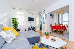 Relax in this inviting living space with a sofa, flat-screen TV, and dining area.