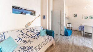 A cozy room with a bed, a desk, and a chair. There is a picture on the wall and a door leading to another room. - Fantastic Seaview Turquoise House (Santa Margherita di Pula)