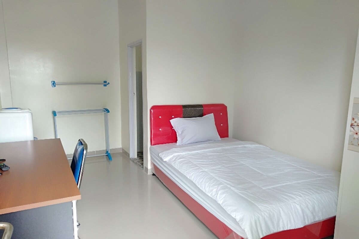Ein Zimmer mit einem Bett, einem Schreibtisch und einem Stuhl.