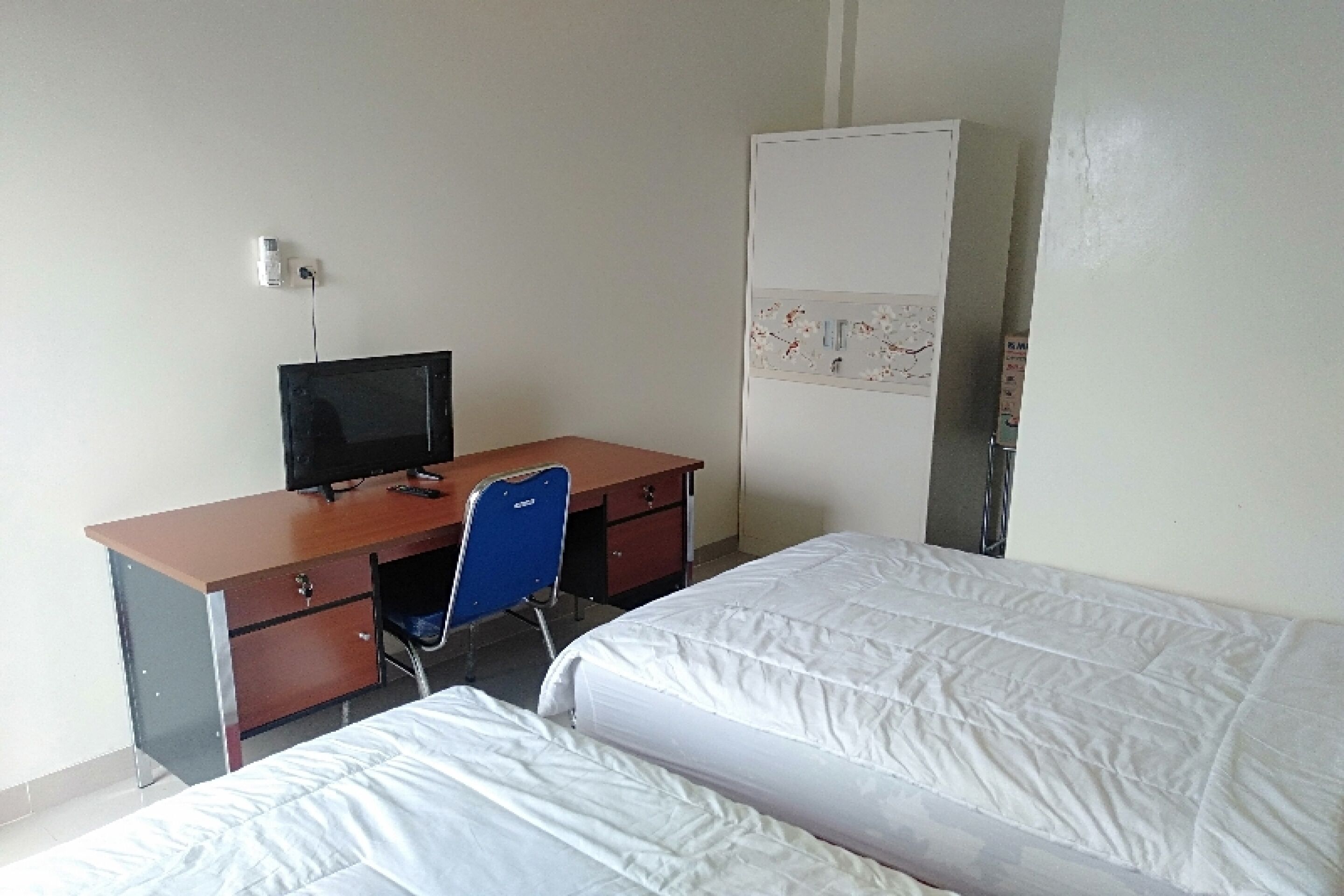 Una habitación con escritorio, silla, cama y armario.