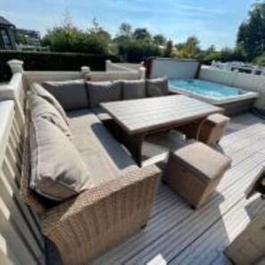 Relax by the pool on a furnished deck surrounded by trees.