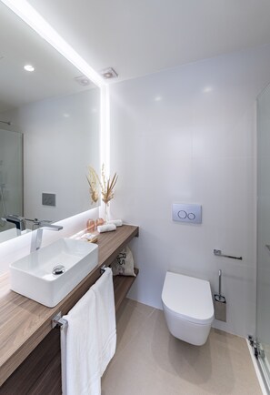 A modern bathroom with a white sink, wooden countertop, and a toilet. - La Casa de las Flores  (Cartagena)