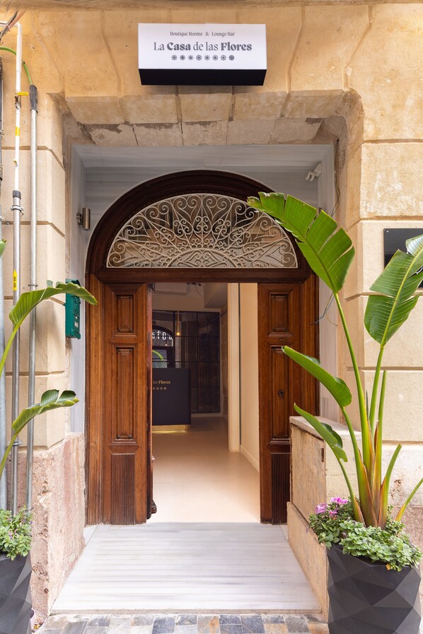 A hotel entrance with a wooden door and an ornate archway. - La Casa de las Flores  (Cartagena)