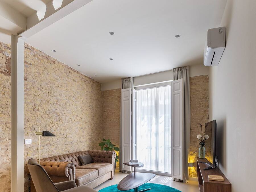 Een moderne woonkamer met een bank, een bijzettafeltje en een televisie.