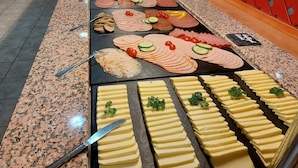 A buffet with various food items including meats, cheeses, and vegetables. - Sporthotel Neuruppin - Apartmenthaus mit Ferienwohnungen (Neuruppin)