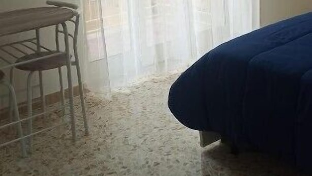Una habitación con cama, una silla y una mesa.