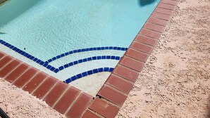 A swimming pool with a tiled edge and a brick border. - Cozy private room in shared residence with pool (San Juan)