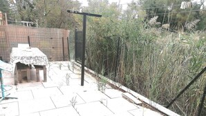 A patio area with a table and chairs, a wooden fence, and a gate.