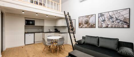 Eine moderne Wohnung mit Schlafgalerie, Essbereich und Wohnzimmer.