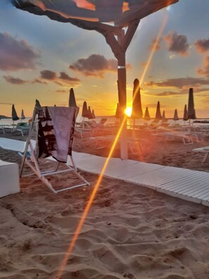 Aan een privéstrand, ligstoelen, parasols, een strandbar