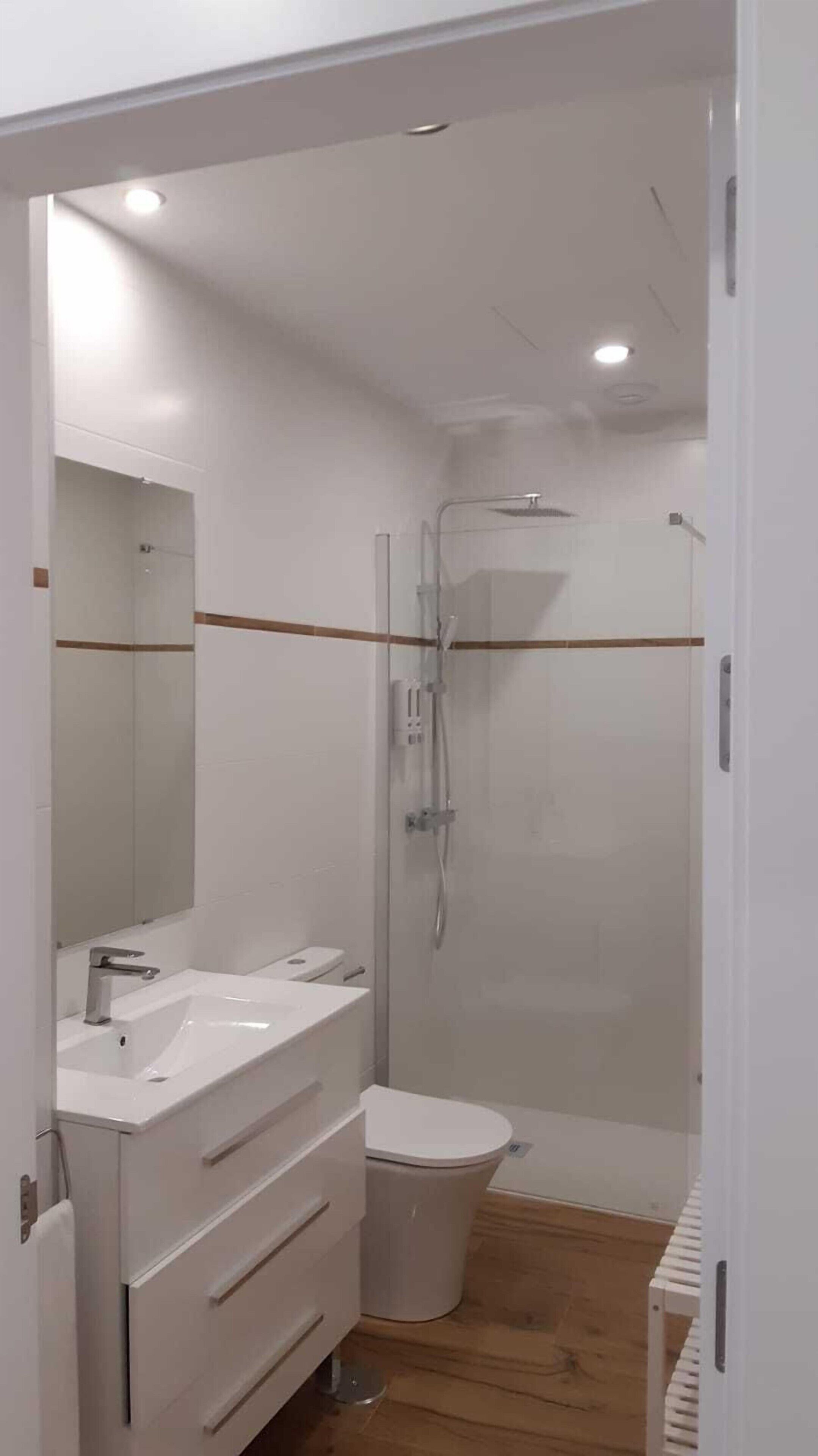 Badkamer | Een douche, een regendouche, een haardroger, handdoeken