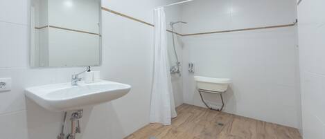 A bathroom with a white sink, mirror, and shower area.
