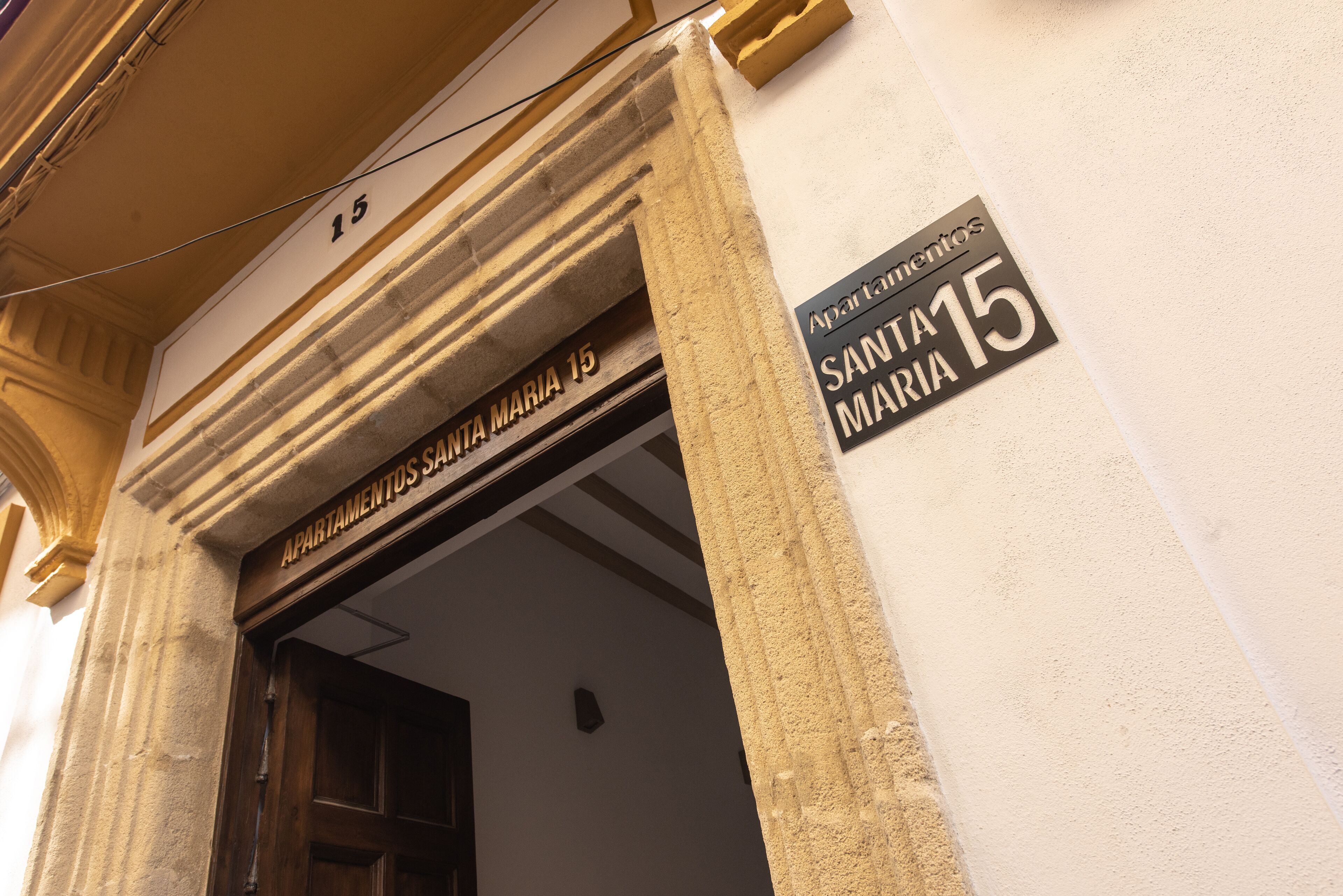 Entrada de un edificio con un letrero que dice "Apartamentos Santa Maria 15".