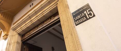 Entrada de un edificio con un letrero que dice "Apartamentos Santa Maria 15".