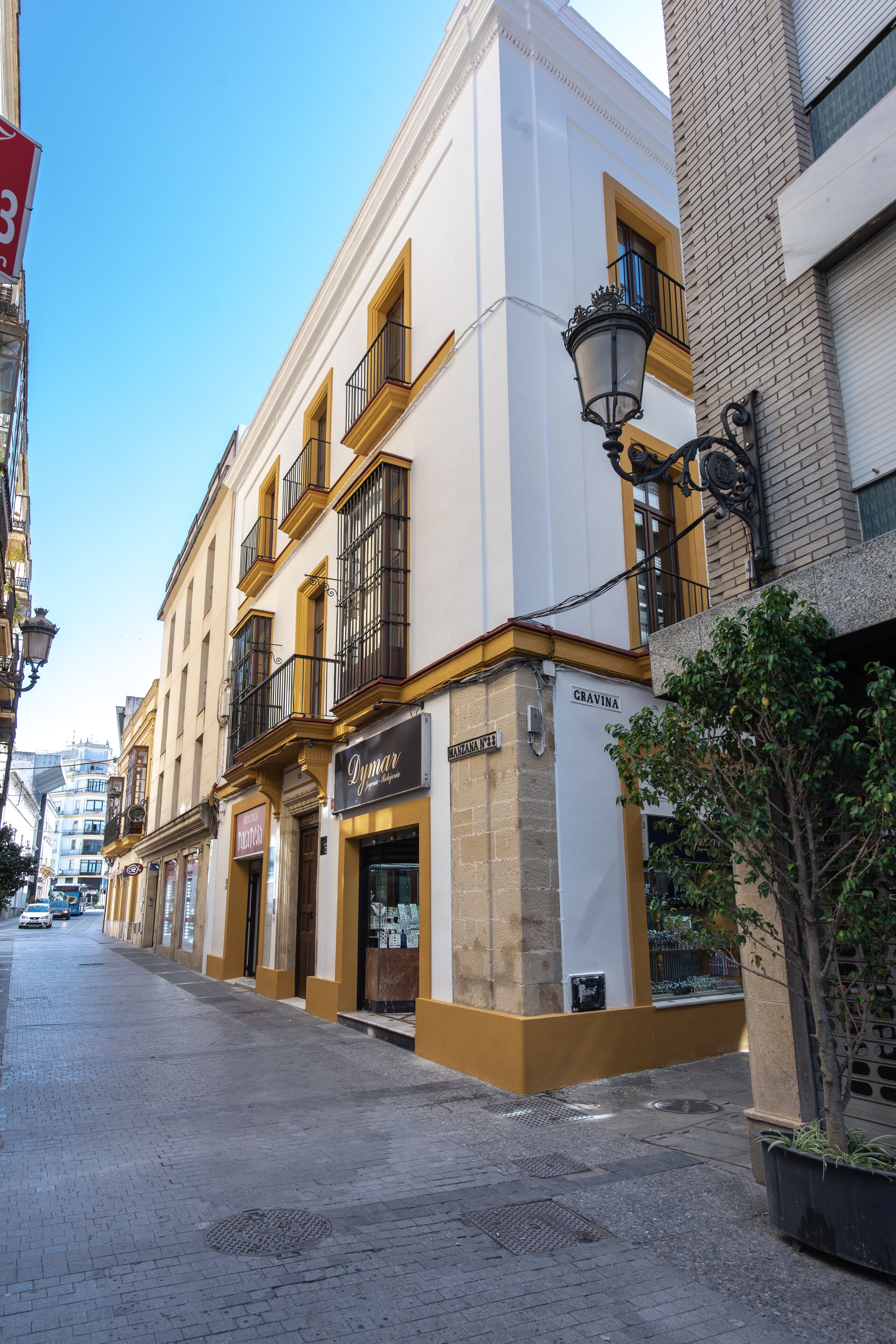 A street with buildings, including a shop with a sign that reads "Gravina".