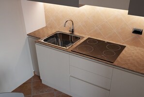 Een oven, een kookplaat, een vriezer, eettafels