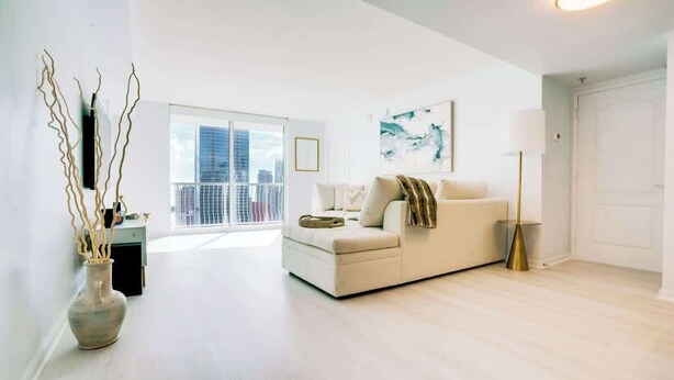 Un salon moderne avec un canapé, un vase et une lampe sur pied.