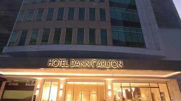 A modern hotel building with a prominent entrance and signage for HOTEL DANN CARLTON.