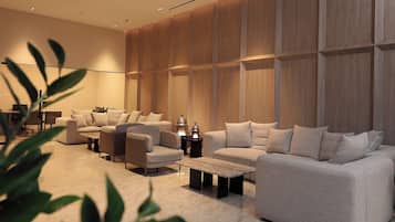Una sala moderna con un sofá modular, una mesa de centro y una mesita de noche con lámpara.