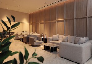 A modern living room with a sectional sofa, a coffee table, and a side table with a lamp. - Hotel Dann Carlton Marinn Place Panama Financial District (Panama City)