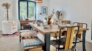 A dining area with a wooden table, chairs, and hanging pendant lights. - "Entre nous"-Quiberon center-10p-Parking-Wifi (Quiberon)