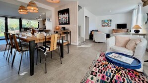 A modern living room with a dining area, a white sofa, and a colorful rug. - "Entre nous"-Quiberon center-10p-Parking-Wifi (Quiberon)